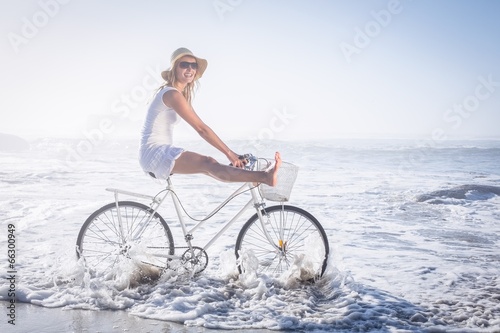 Photo: Gorgeous happy blonde on a bike ride at the beach Gorgeous happy blonde on a bike ride at the beach