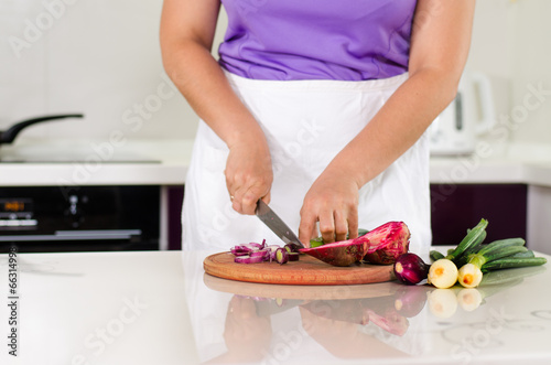 Photo: Housewife chopping vegetables in the kitchen Housewife chopping vegetables in the kitchen