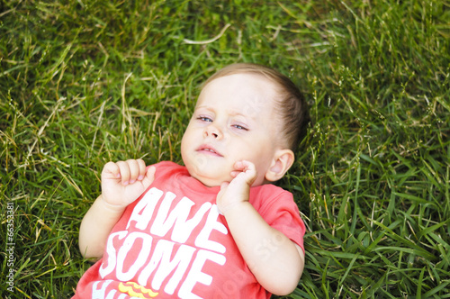 Photo: Small sad boy on grass Small sad boy on grass