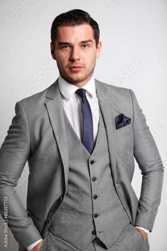 Photo: young fashion business man standing with his hands in his pocket young fashion business man standing with his hands in his pocket