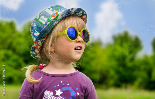 Photo: Adorable little girl in trendy sunglasses Adorable little girl in trendy sunglasses