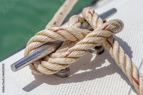 Photo: Nautical knot rope tied around stake on boat or ship Nautical knot rope tied around stake on boat or ship
