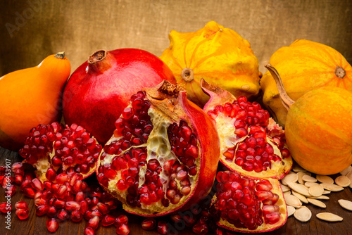 Photo: pumpkin and pomegranate on fabric background pumpkin and pomegranate on fabric background