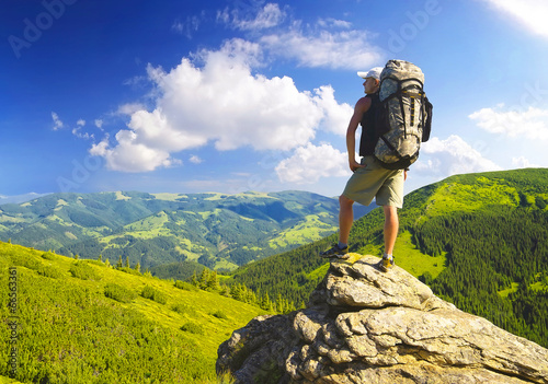 Photo: Tourist on peak. Sport and active life concept Tourist on peak. Sport and active life concept