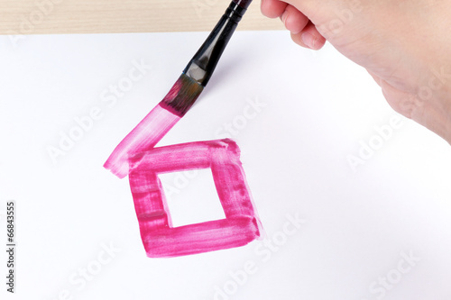 Photo: Child draws house with watercolors, close up Child draws house with watercolors, close up