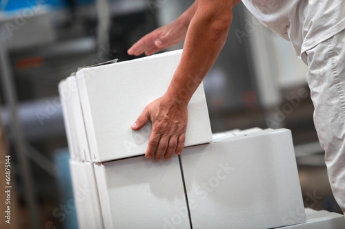 Photo: Manual worker working with boxes in factory Manual worker working with boxes in factory
