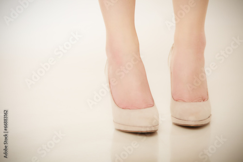 Photo: Closeup of female feet in beige high heels. Closeup of female feet in beige high heels.