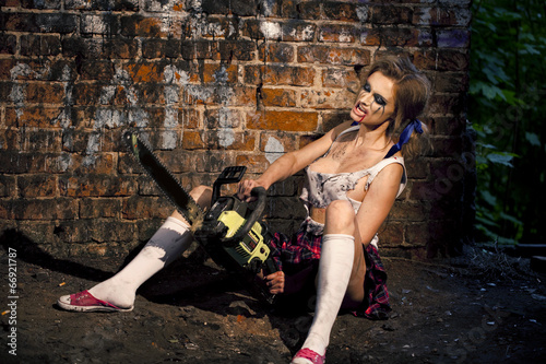 Photo: Psychotic woman with a chainsaw covered in blood Psychotic woman with a chainsaw covered in blood