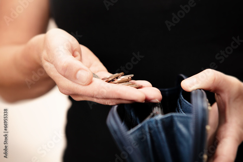 Photo: woman holding money over purse woman holding money over purse