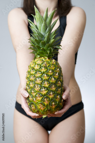 Photo: Overweight of the women with pineapple Overweight of the women with pineapple