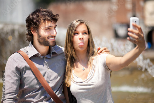Photo: Happy couple taking a selfie in the city Happy couple taking a selfie in the city