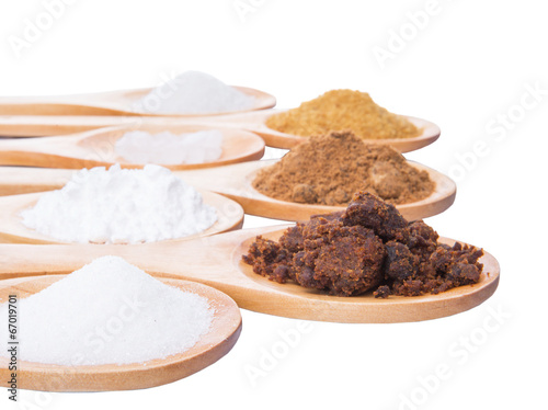 Photo: Various type of sugar on wooden spoon over white background Various type of sugar on wooden spoon over white background