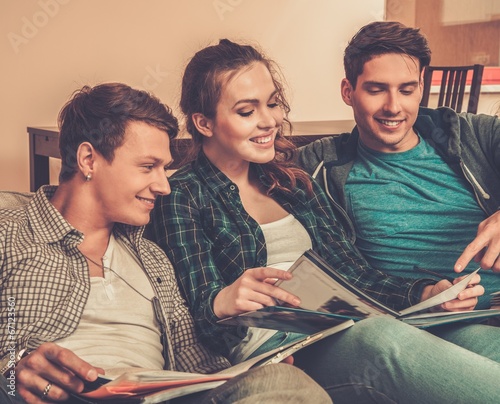 Photo: Three young students preparing for exams in apartment interior Three young students preparing for exams in apartment interior