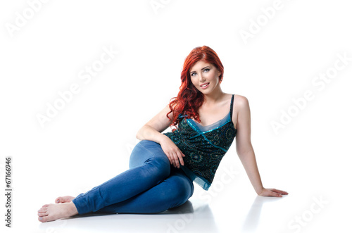 Photo: Young beautiful woman sitting on the floor, isolated on white Young beautiful woman sitting on the floor, isolated on white