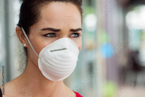 Photo: Woman wearing mask in city. Woman wearing mask in city.