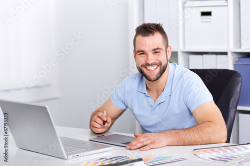 Photo: Graphic designer using a graphics tablet in a modern office Graphic designer using a graphics tablet in a modern office