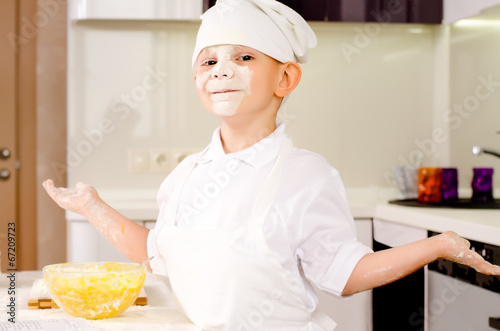 Photo: Proud playful little boy in a chefs uniform Proud playful little boy in a chefs uniform