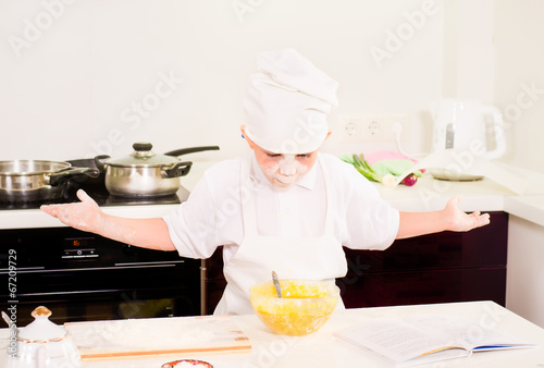 Photo: Proud playful little boy in a chefs uniform Proud playful little boy in a chefs uniform