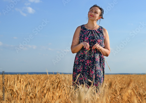 Photo: Smiling happy woman in a golden field of wheat Smiling happy woman in a golden field of wheat