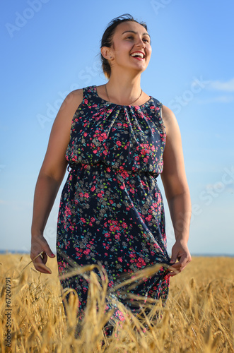 Photo: Laughing tanned vivacious woman in a wheat field Laughing tanned vivacious woman in a wheat field