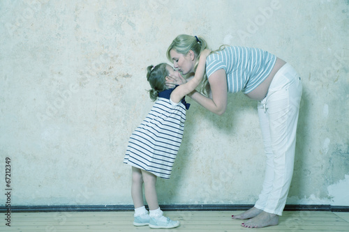 Photo: Tochter umarmt Mama mit Babybauch Tochter umarmt Mama mit Babybauch