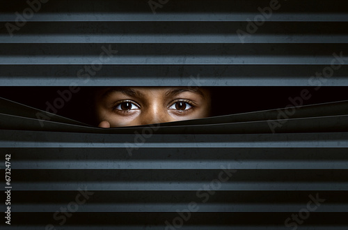 Photo: Child looking through window blinds Child looking through window blinds