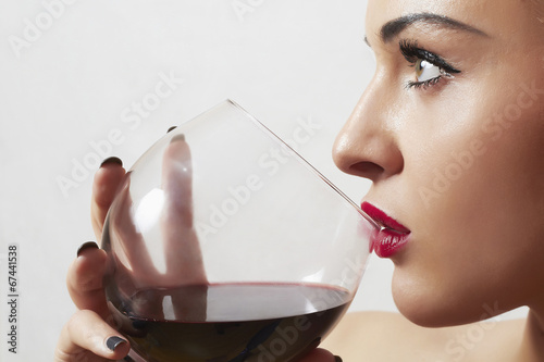 Photo: Beautiful blond woman drinking red wine.girl with wineglass Beautiful blond woman drinking red wine.girl with wineglass