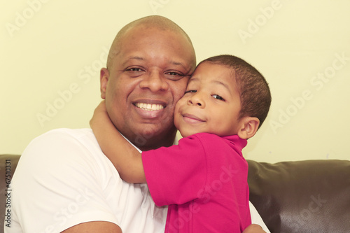 Photo: Portrait of african father and his son. Focus in the kid. Portrait of african father and his son. Focus in the kid.