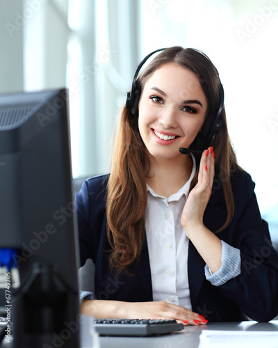 Photo: Female customer support operator with headset and smiling Female customer support operator with headset and smiling