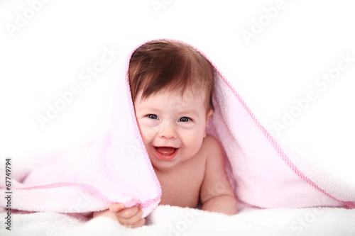 Photo: smiling baby looking at camera under a white blanket/towel smiling baby looking at camera under a white blanket/towel