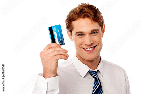 Photo: Smiling corporate guy holding credit card Smiling corporate guy holding credit card