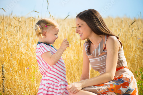 Photo: Happy young mother with daughter playing field Happy young mother with daughter playing field