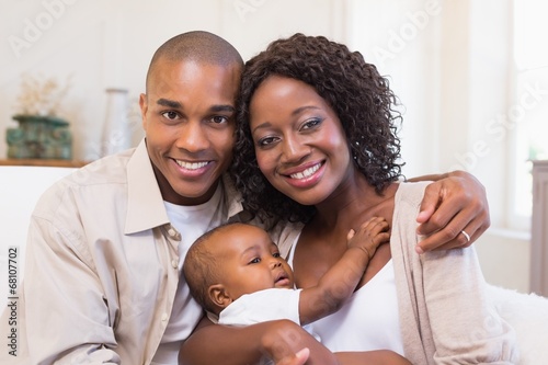 Photo: Happy parents spending time with baby on the couch Happy parents spending time with baby on the couch
