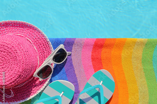 Photo: Tablet with blank screen by poolside with beach accessories Tablet with blank screen by poolside with beach accessories