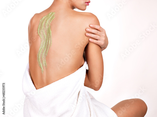 Photo: woman cares about skin of body using cosmetic scrub on the back woman cares about skin of body using cosmetic scrub on the back
