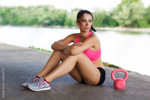 Photo: Woman sit with pink kettlebell Woman sit with pink kettlebell