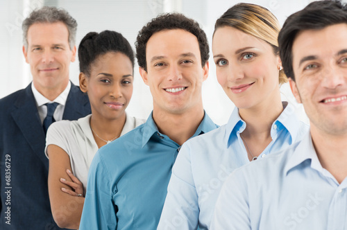 Photo: Satisfied Businesspeople Standing In A Row Satisfied Businesspeople Standing In A Row