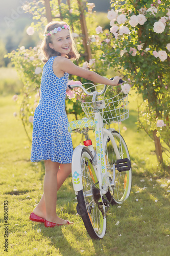 Photo: Summer joy - girl with bicycle in summer garden Summer joy - girl with bicycle in summer garden