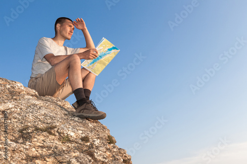 Photo: Tourist with a map looks into the distance Tourist with a map looks into the distance
