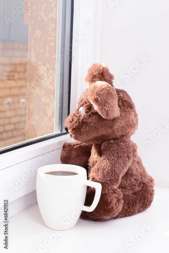 Photo: Toy-bear looking out window close-up Toy-bear looking out window close-up