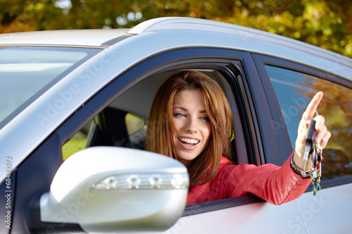 Photo: Happy smiling woman with car key. Driving. Happy smiling woman with car key. Driving.