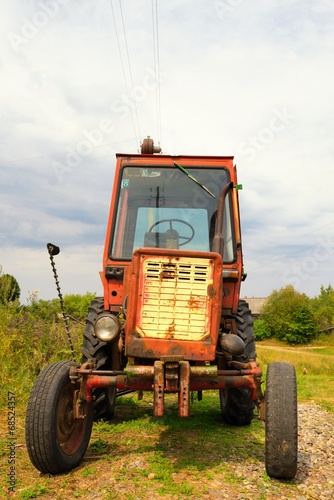 Photo: Old Russian tractor in the yard of a farm Old Russian tractor in the yard of a farm