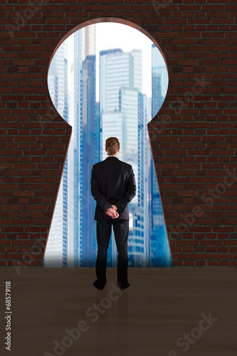 Photo: Businessman Looking At City Buildings Through Key Hole Businessman Looking At City Buildings Through Key Hole