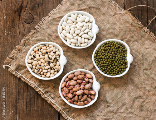 Photo: Assortment of legumes in bowls on wooden table Assortment of legumes in bowls on wooden table