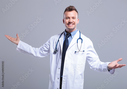 Photo: young smiling doctor welcoming you young smiling doctor welcoming you