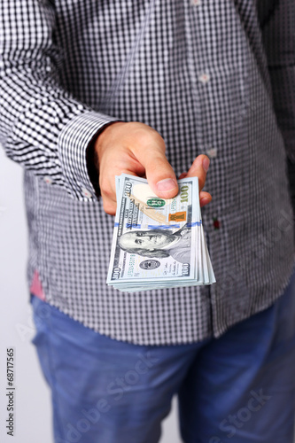 Photo: Closeup portrait of a male hand holding US dollars Closeup portrait of a male hand holding US dollars