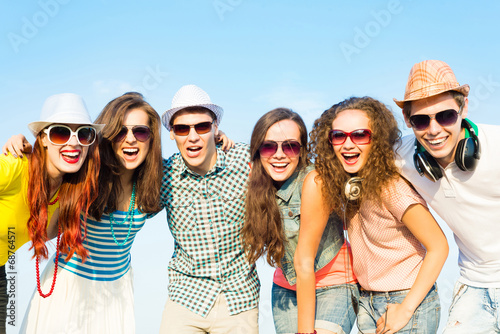Photo: group of young people wearing sunglasses and hat group of young people wearing sunglasses and hat