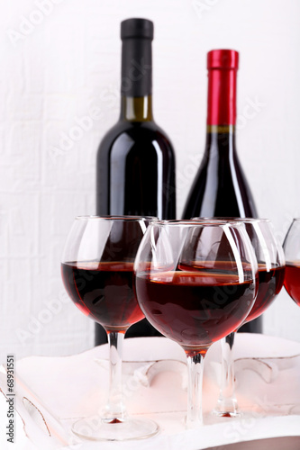 Photo: Glasses and wine bottle on tray in room Glasses and wine bottle on tray in room