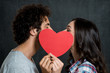 Couple Kissing Behind Paper Heart