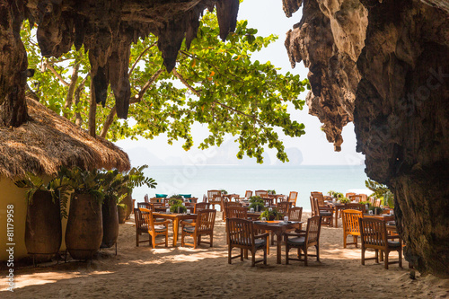 view to open-air restaurant on beach from cave